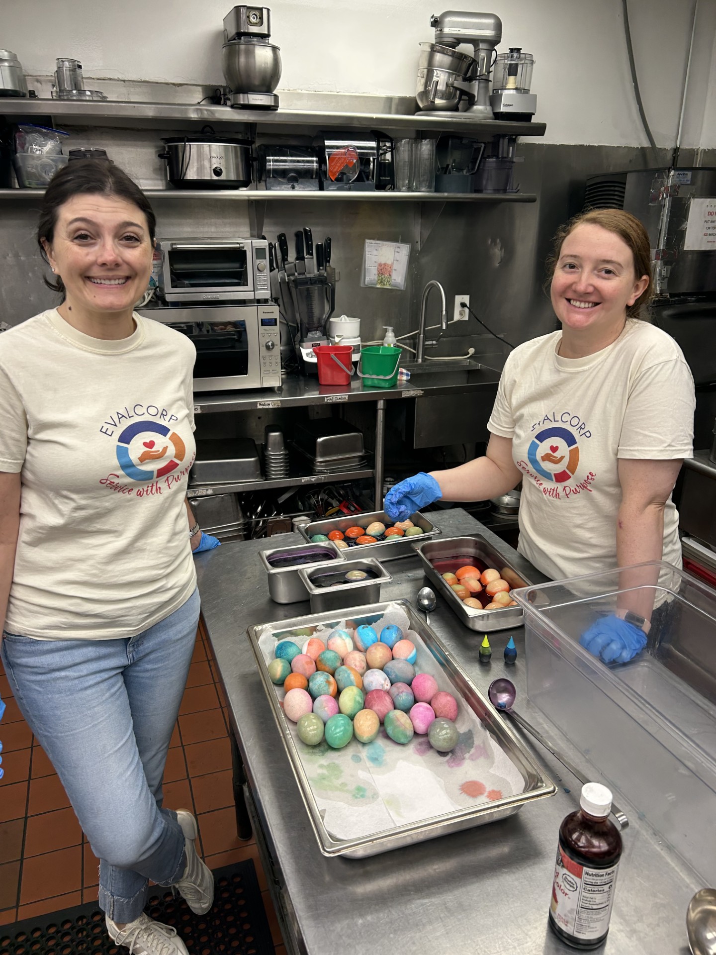 Photo of team members Allison and Shayla dying eggs in community kitchen