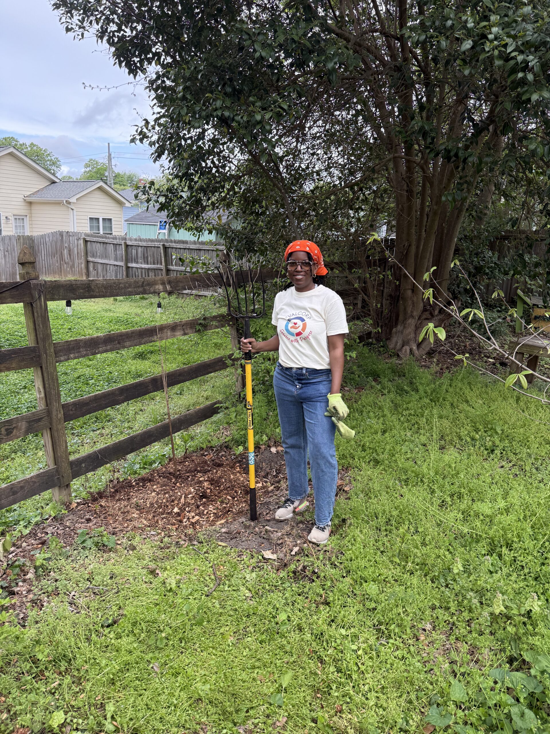 Photo of team member Gabby with gardening tool at community garden in North Carolina