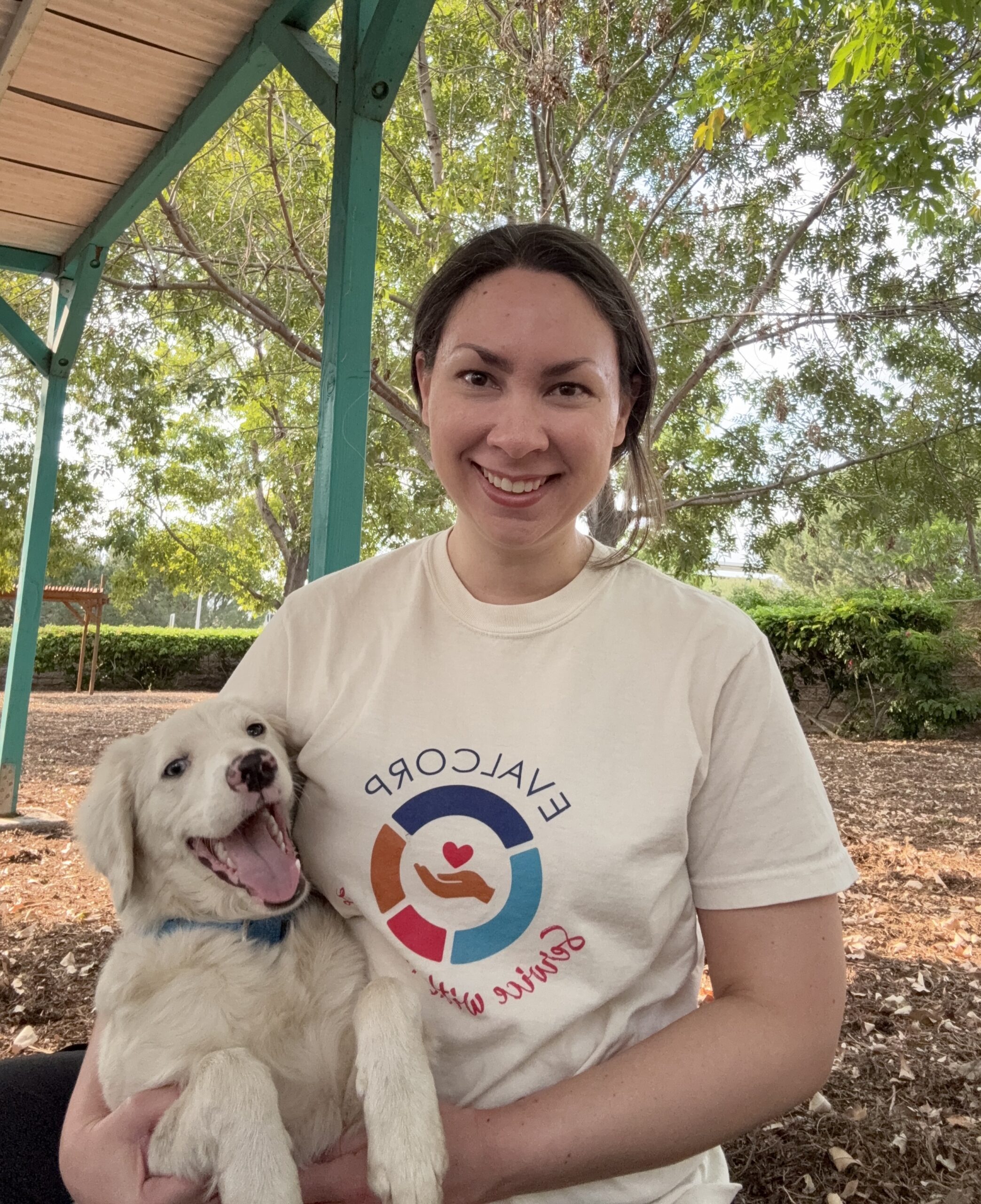 Photo of team member Taylor volunteering at an animal shelter with a white puppy