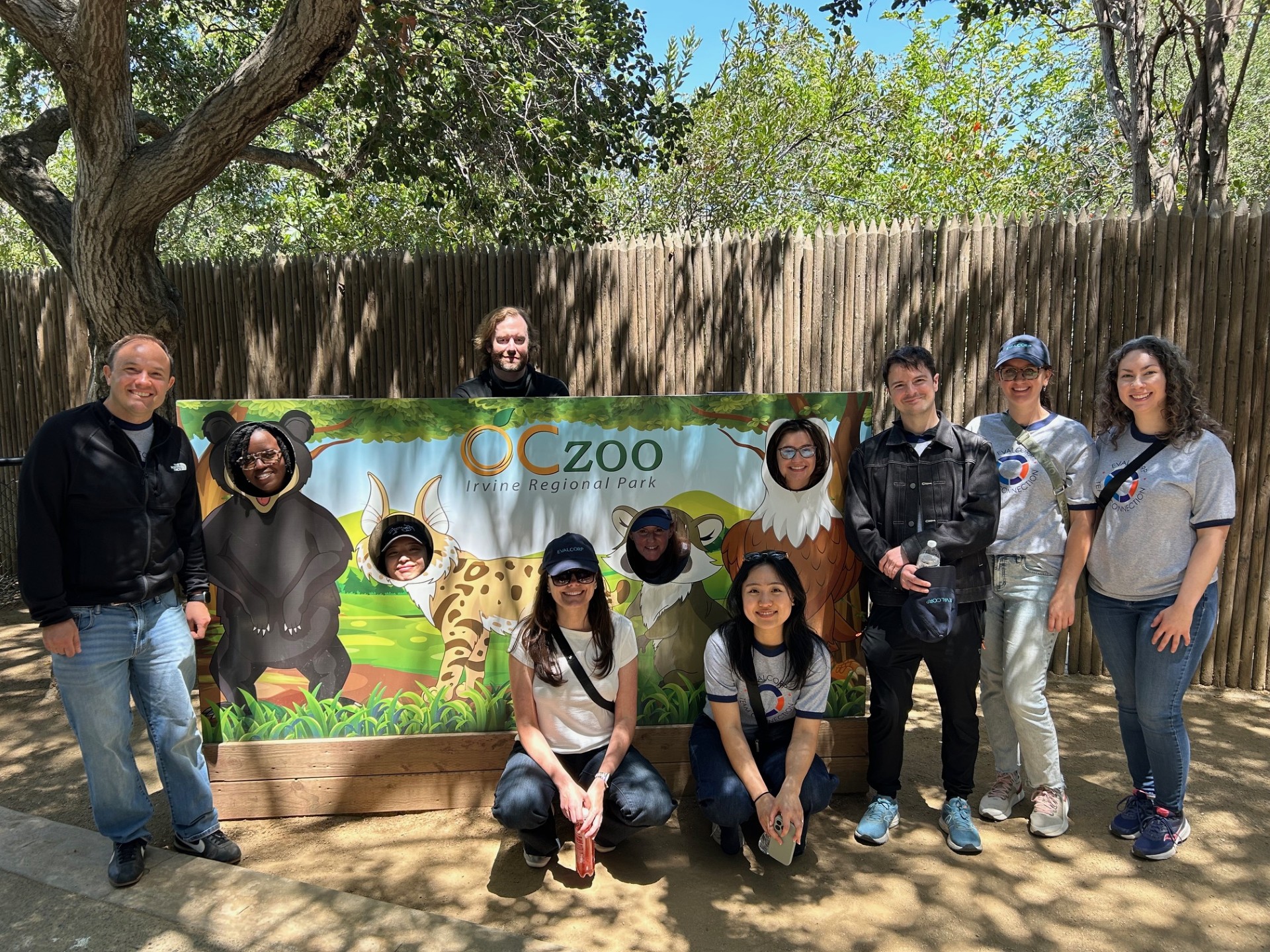 Team members posing with a sign at the Zoo
